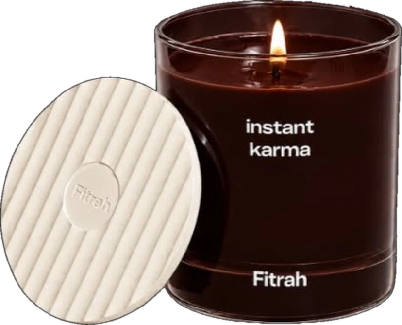 Fitrah Instant Karma candle in espresso glass, lit, beside its ribbed ceramic lid